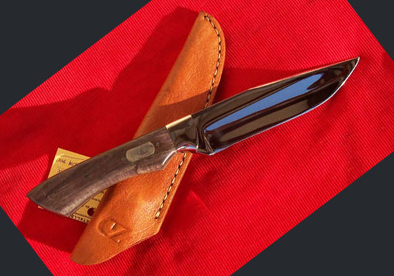 #5 - CUCHILLO DE ASADO<br />
								HOJA: Acero inoxidable 420 Mov. contratamientos termico y prueba de dureza Rockwell, tambien en acero al carbono SAE 5160.Largo 13cm aprox.
								CRUZ: Tapas de Bronce.
								CABO: En madera dura de Retamo, Quebracho Colorado, Itin, Guayacan o Guayubira.
								VAINA: Cuero cosido a mano.